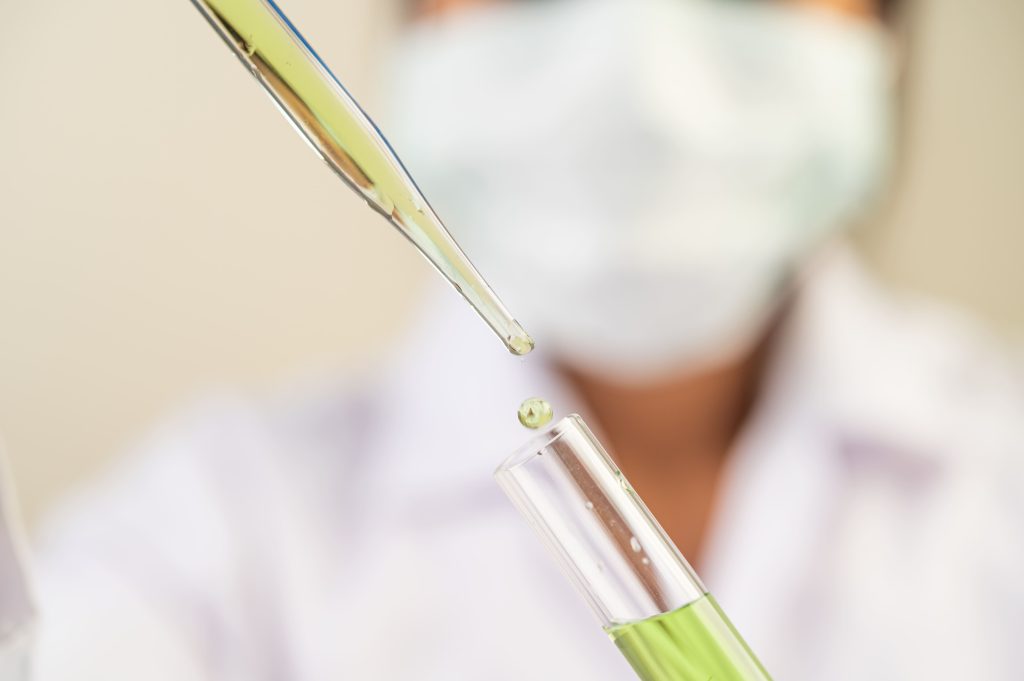 scientists wear masks gloves carrying beakers with vaccines